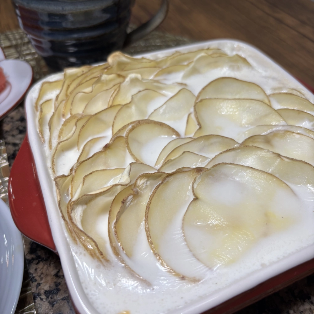 Baked Sliced Potatoes with Cheesy White Sauce